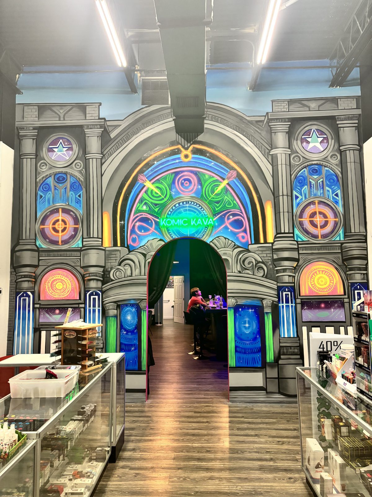 Komic Kava neon-lit comic mural archway entrance inside Vibe City Smoke Shop in Boca Raton
