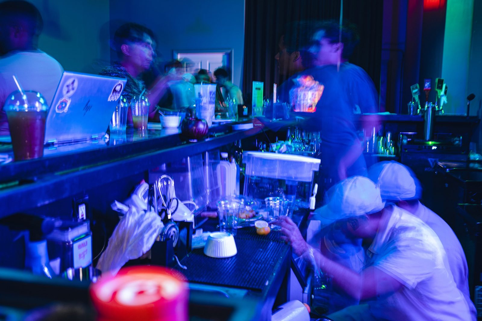 Busy Komic Kava bar during a party with kava and kratom drinks lined up along the comic art bar
